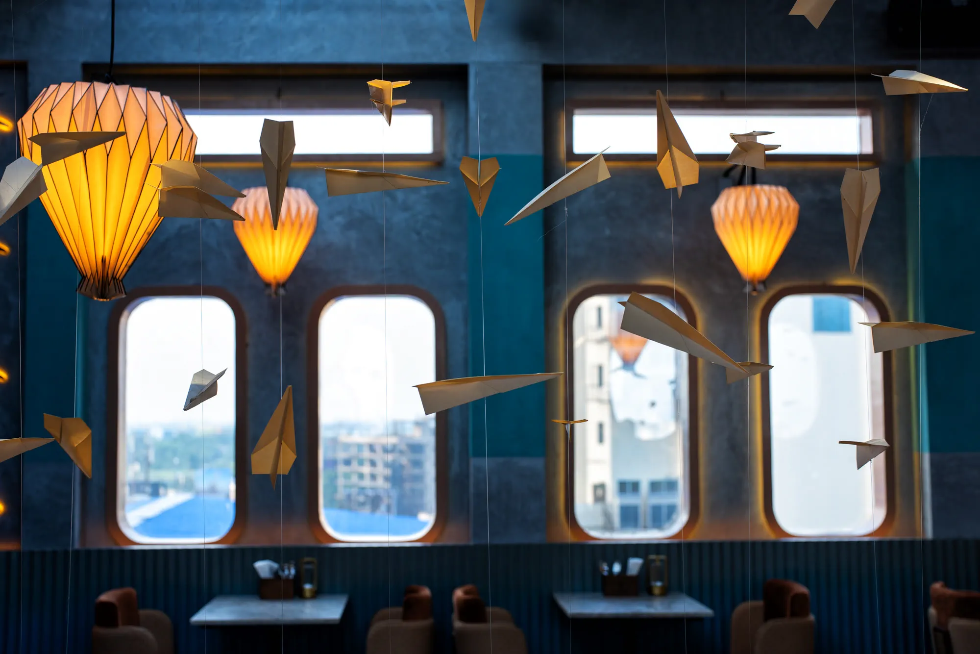 Aerosky Bar & Kitchen, paper planes along the window line catching the light off the city