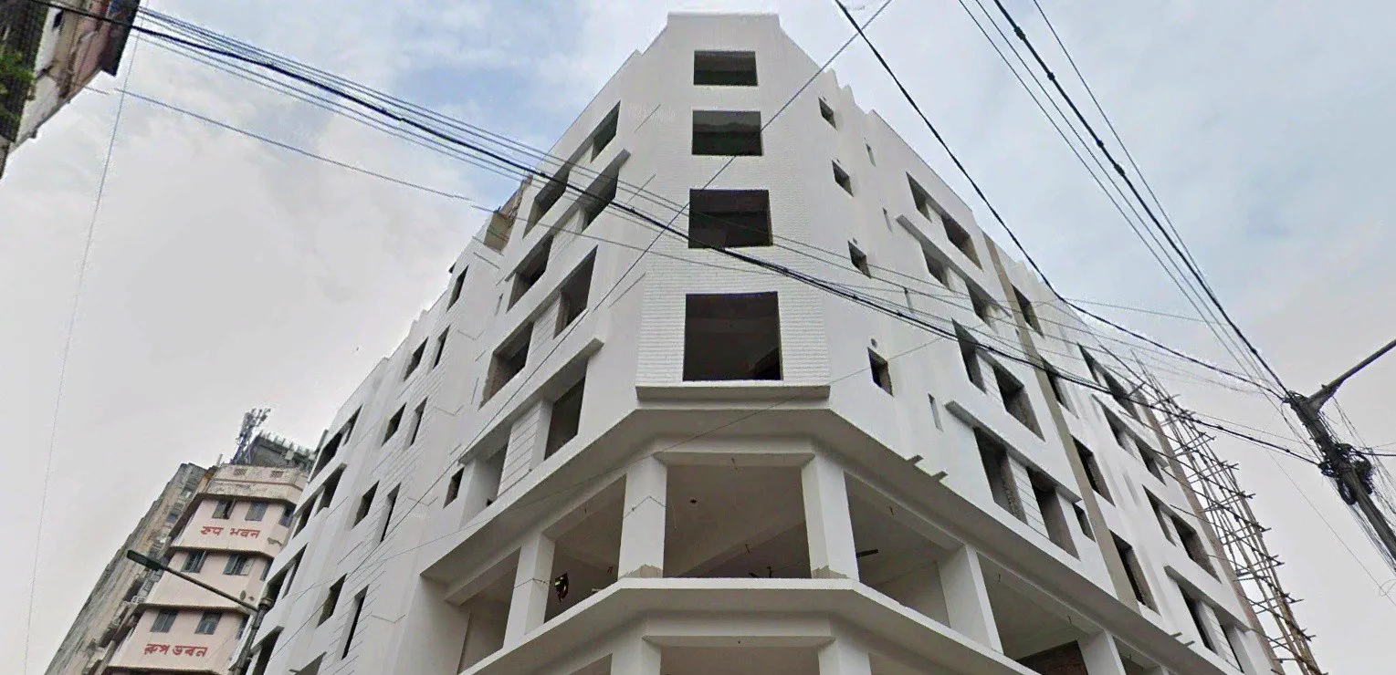 The corner of the building from below, openings formed and frame painted — Google Street View capture
