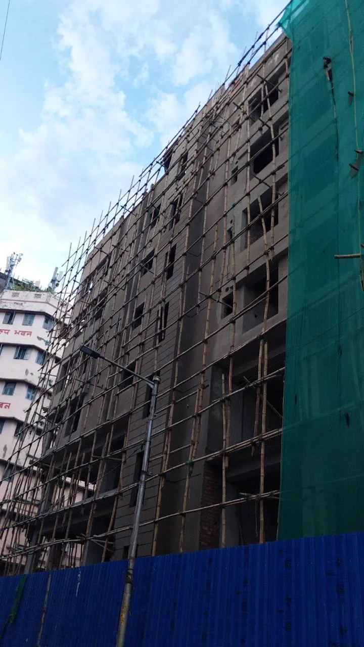 The concrete frame under bamboo scaffolding and green netting