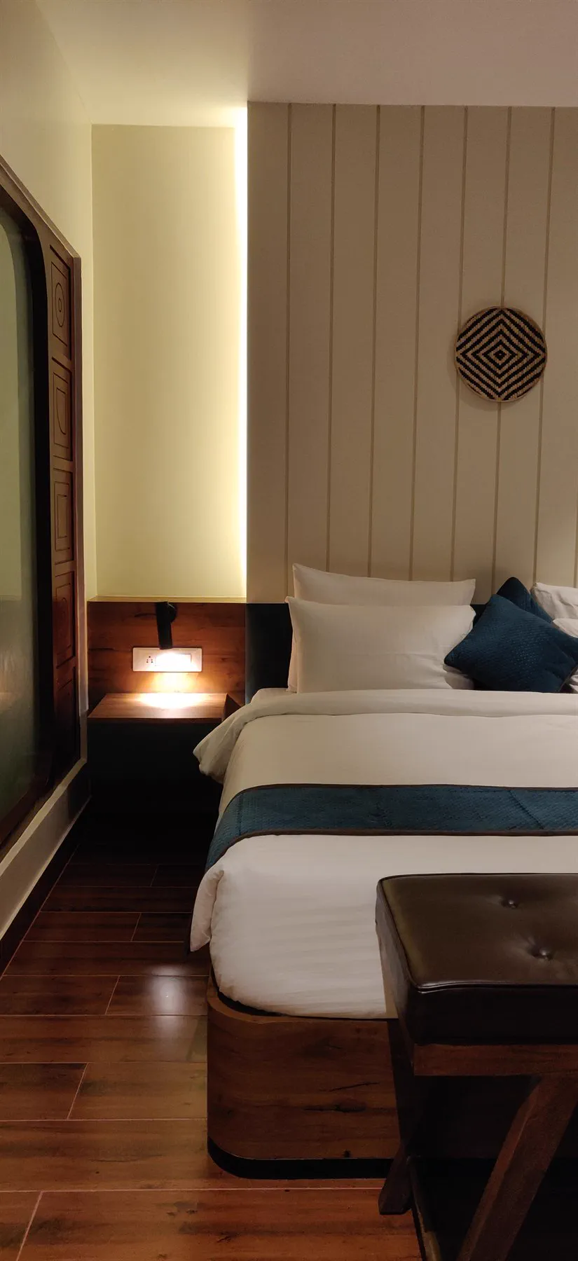 Bedside detail with a reading light set into the timber headboard band