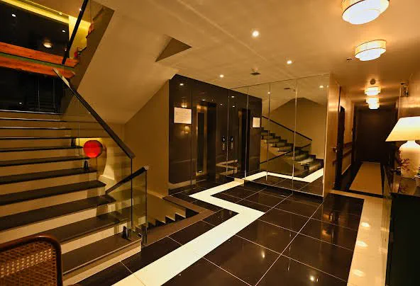 The lift lobby with a glass-balustraded stair and inlaid floor