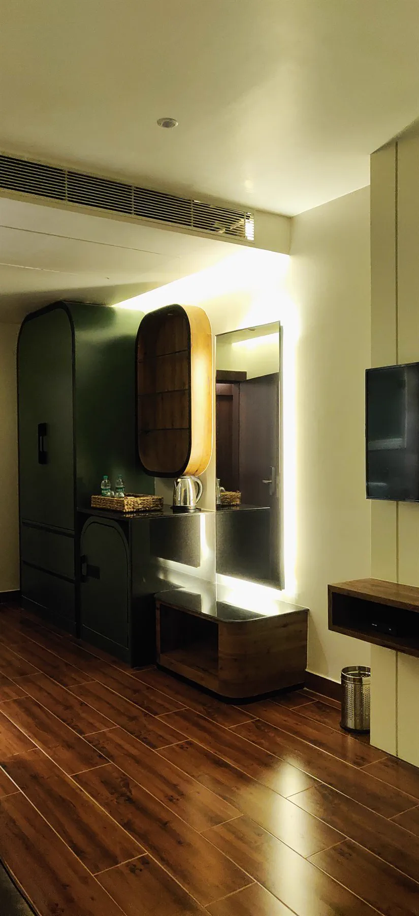 The built wardrobe and minibar nook with a backlit mirror
