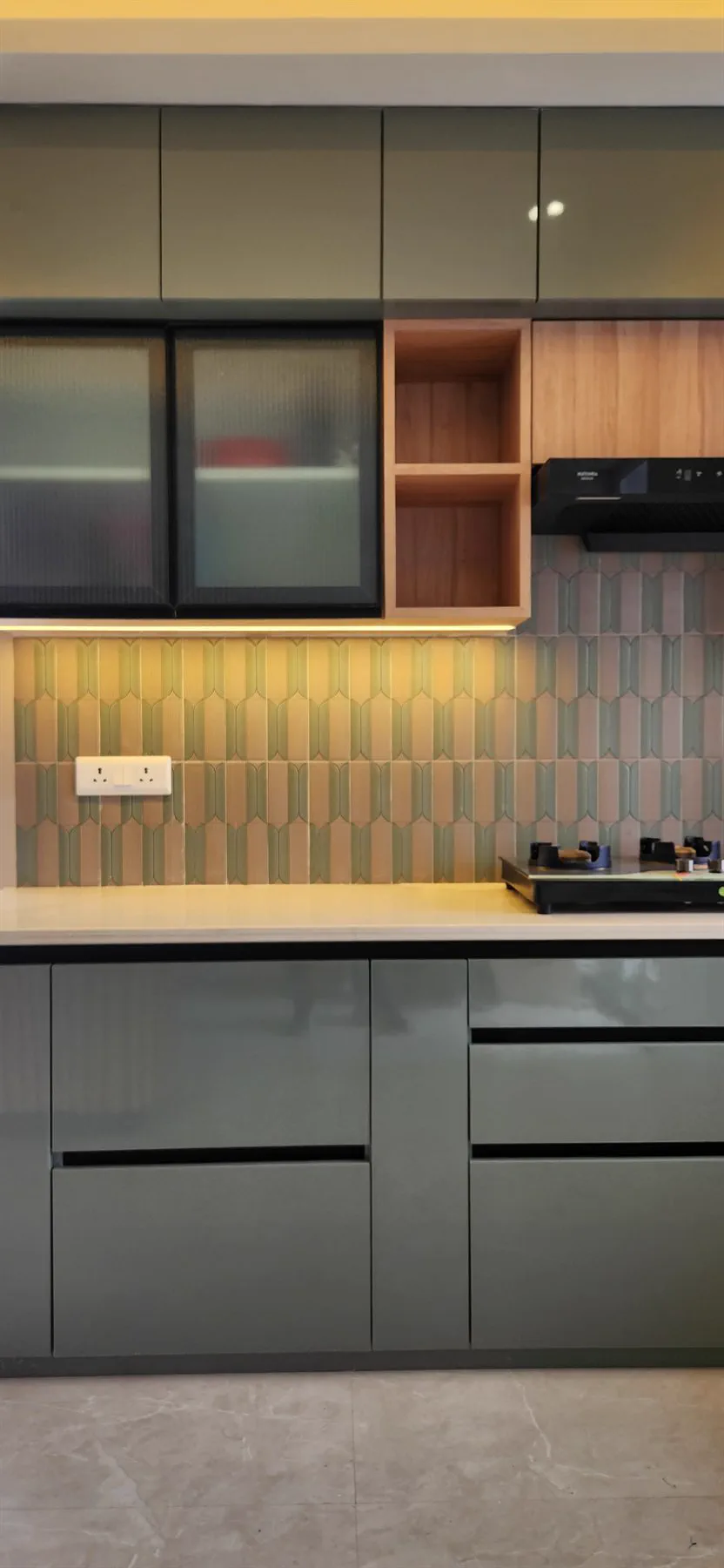 Olive kitchen cabinetry against a picket-tile backsplash with reeded glass above