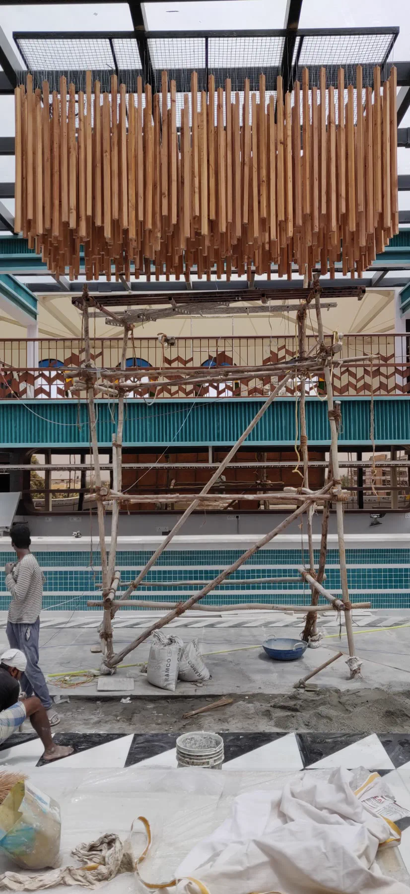 What The Ale mid-build — the hanging timber slat ceiling in place above bamboo staging, with the team on site