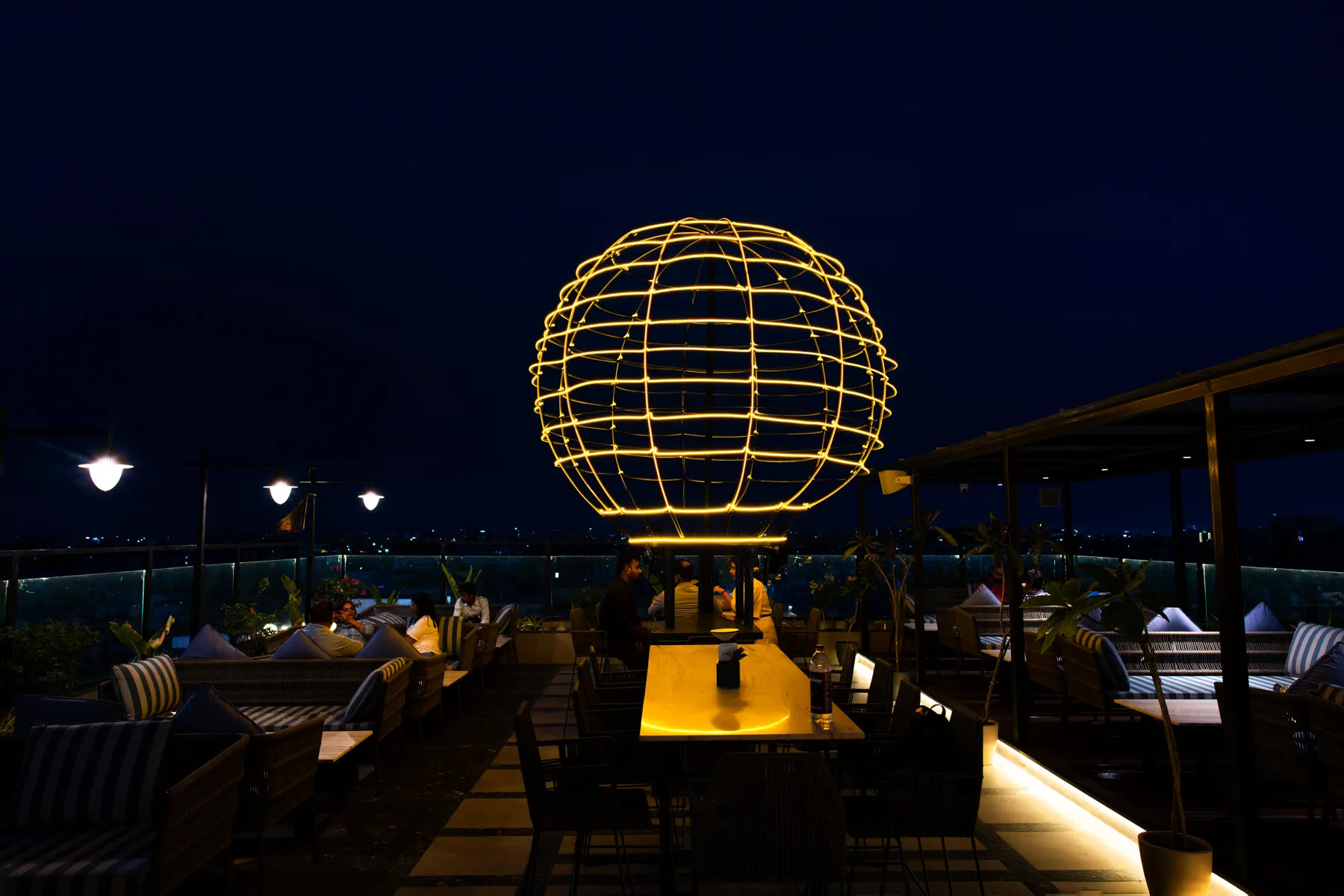 Aerosky's rooftop at night, the illuminated wire-frame balloon sculpture above the terrace