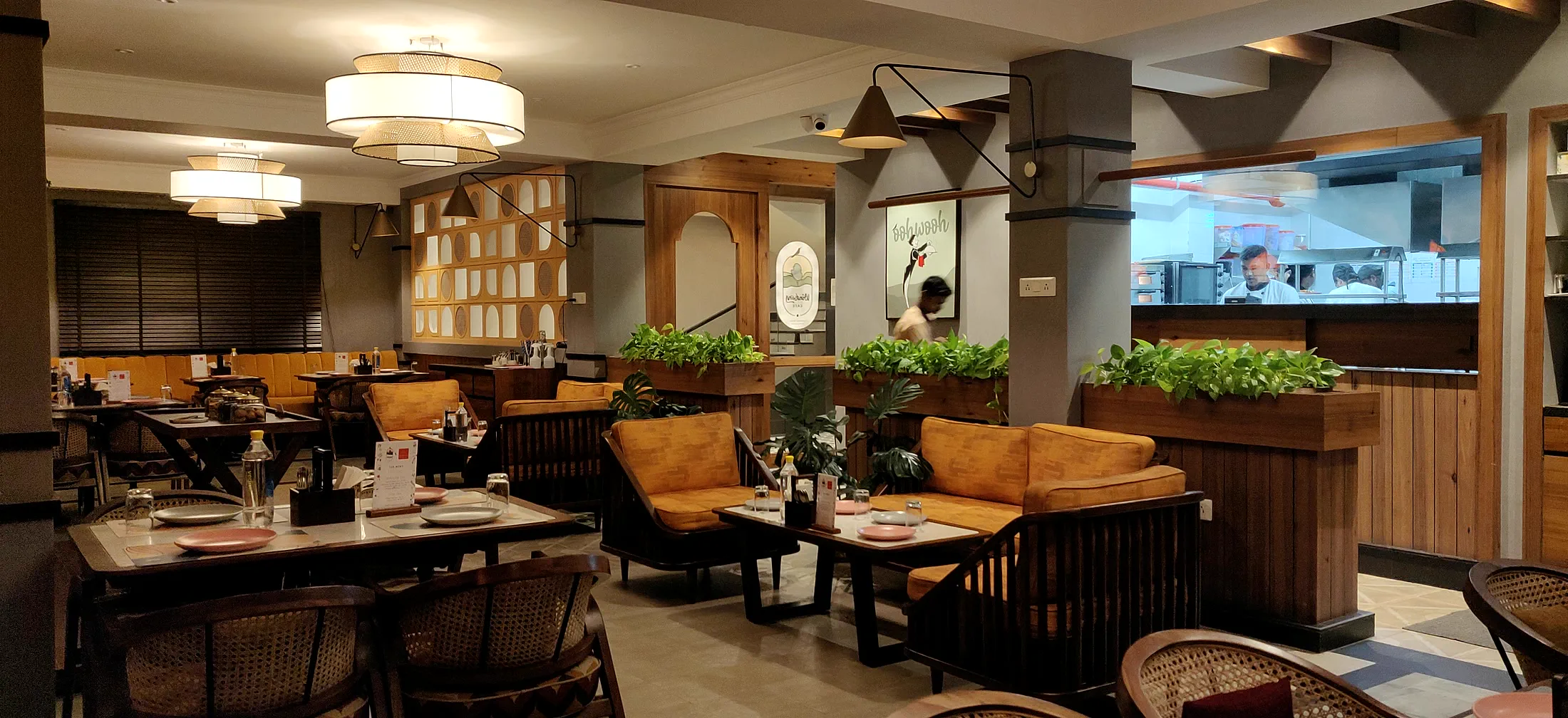 Windsong Cafe &mdash; the corner seating, timber banquettes and planting under pendant light