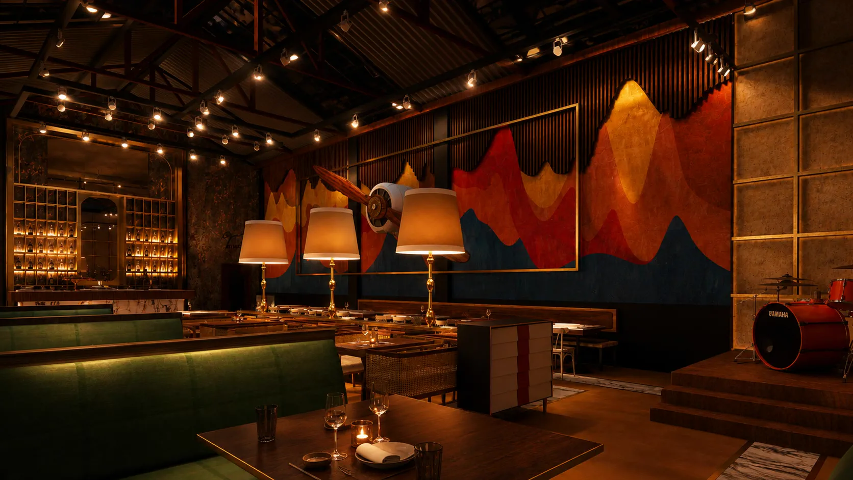 The mural wall at night, the propeller lit against layered peaks of blue, red and gold