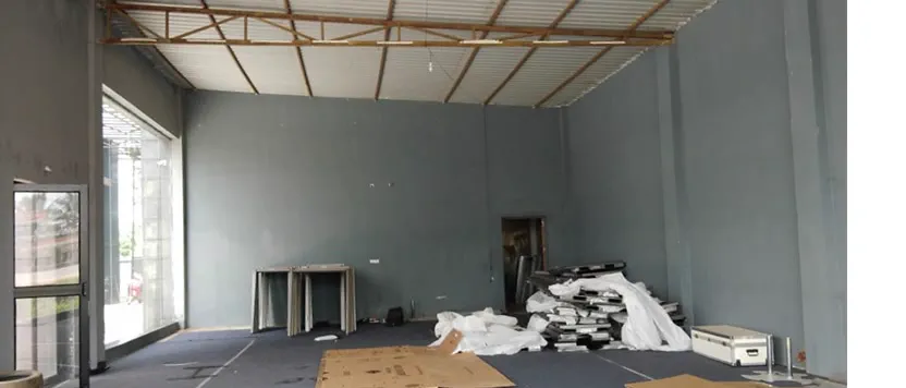 The empty shell inside, packing material and stacked frames on a bare floor