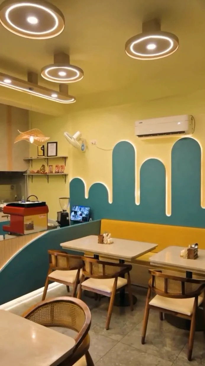 Built: the arched wall panels in teal outlined in warm LED, above a mustard banquette