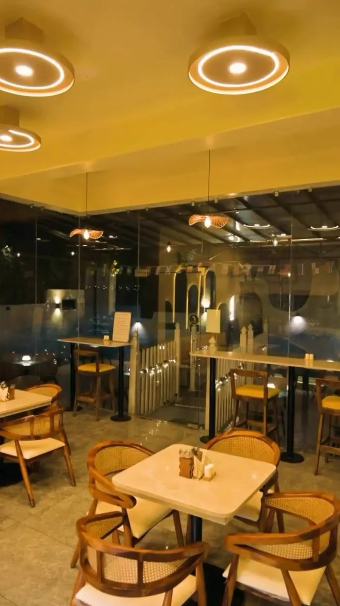 Built: the glass line at night with the picket fence and the pet run beyond it, bunting strung above