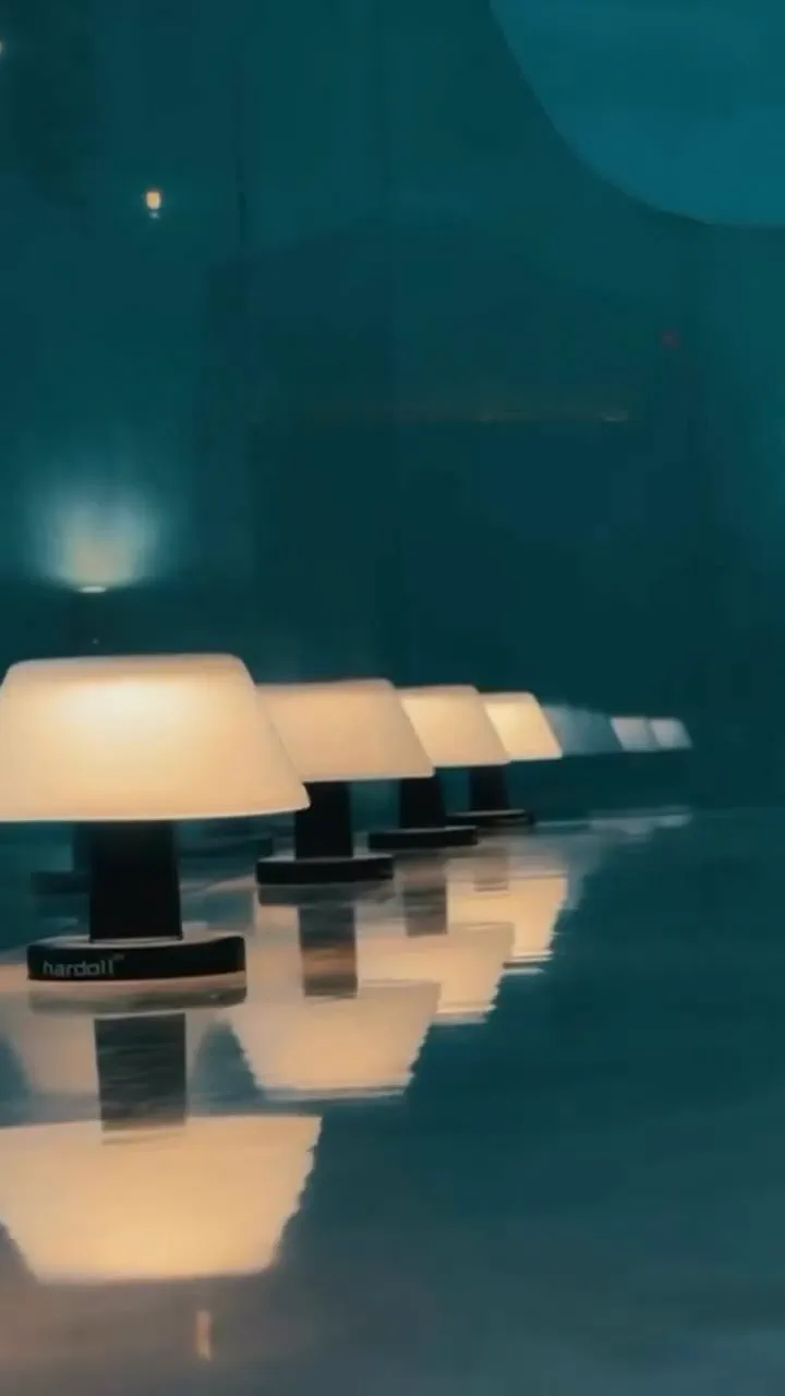 Built: a row of cordless mushroom table lamps lit and reflected along a polished dark top