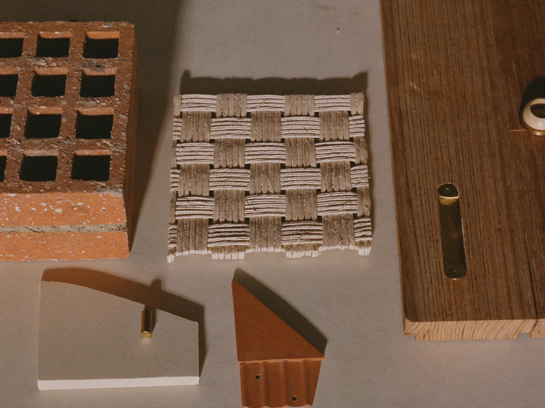 A specimen board of the studio's materials — brick, timber, cane and lime samples