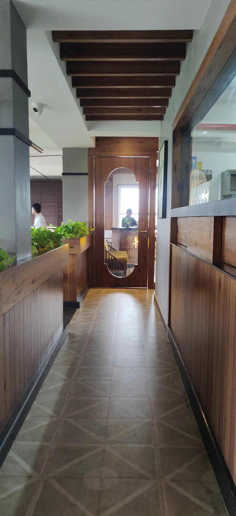 The built corridor leading to the entrance, with exposed timber beams