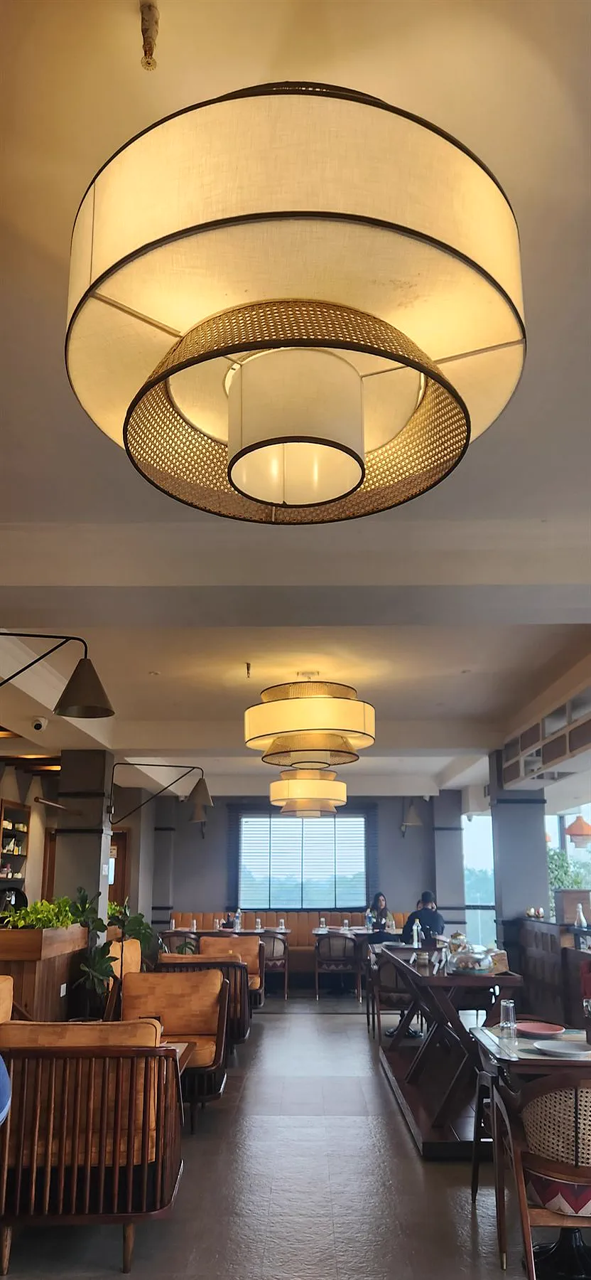 The layered cane and fabric pendant above the dining room