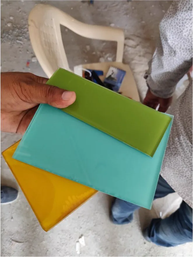 Three coloured glass samples held up on site