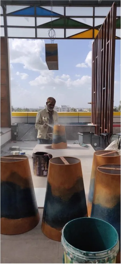Conical light shades being duco sprayed on the terrace